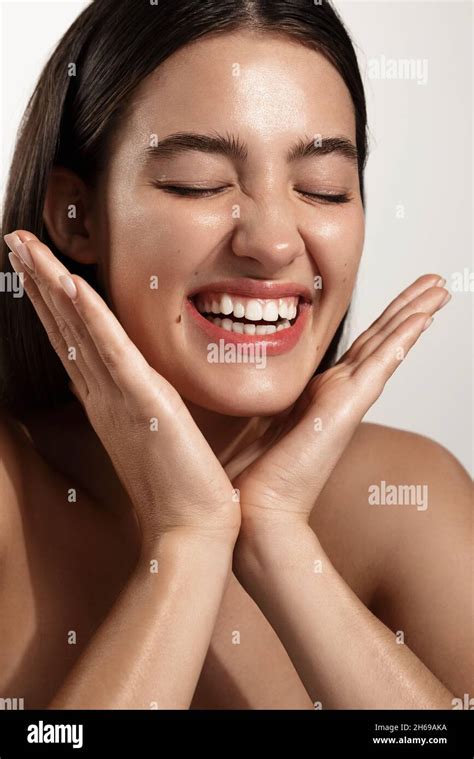 skin care and cosmetology happy model splash her face after cleansing gel smiling pleased