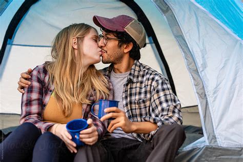 Young Couple Kiss Each Other While In Tent On Camping Trip By Stocksy Contributor Mckinsey