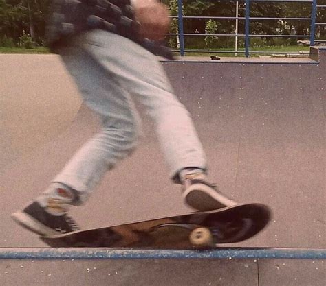 A Man Riding A Skateboard Down The Side Of A Blue Rail At A Park