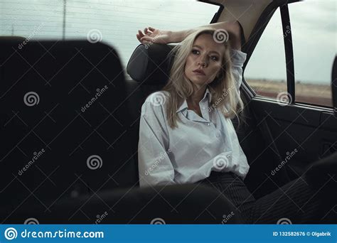 Portrait Of Beautiful Woman Sitting Relaxed On The Back Seat Of The Car