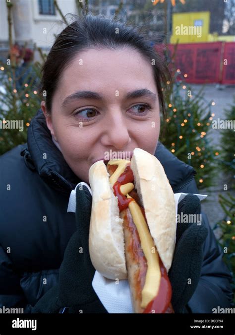 Woman Eating A Large Bratwurst Sausage With Bread In Berlin Germany