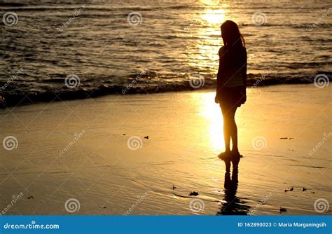 Silhouette Of A Woman On The Beach At Sunset A Girl Standing Alone