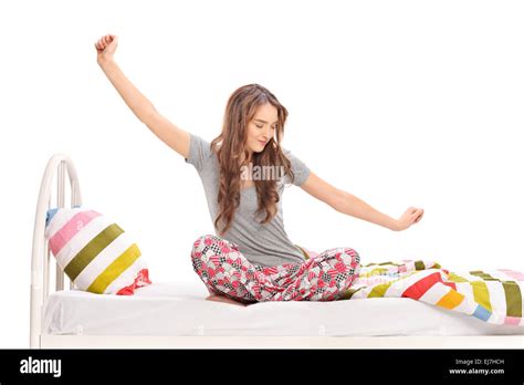 Beautiful Woman Waking Up In The Morning And Stretching Seated On A Bed