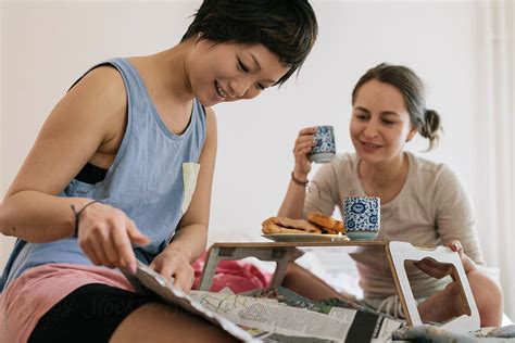 lesbian couple reading newspaper while having breakfast del colaborador de stocksy vegterfoto