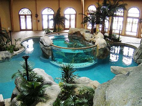 An Indoor Swimming Pool Surrounded By Rocks And Palm Trees