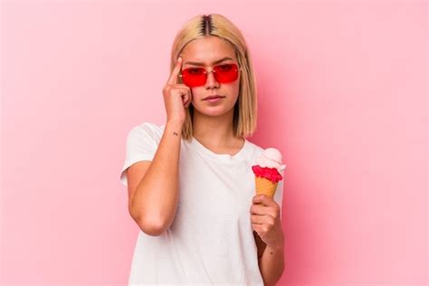 Premium Photo Young Venezuelan Woman Eating An Ice Cream Isolated On Pink Wall Pointing Temple