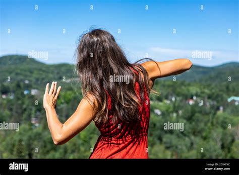 View From Behind Of A Slender Young Woman In A Red Dress Dancing A Ritual Energetic Dance In The