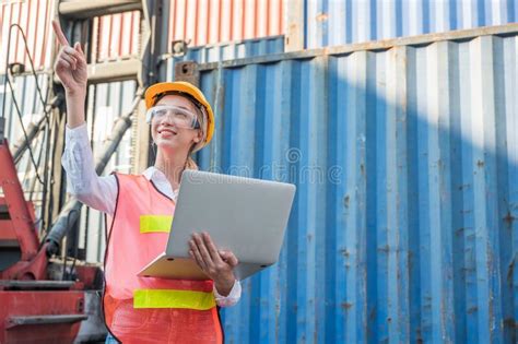 foreman woman worker working checking at container cargo harbor holding laptop computer to