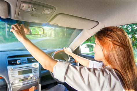 Young Asian Woman Driver Adjusting Her Rearview Mirror In The Car Stock