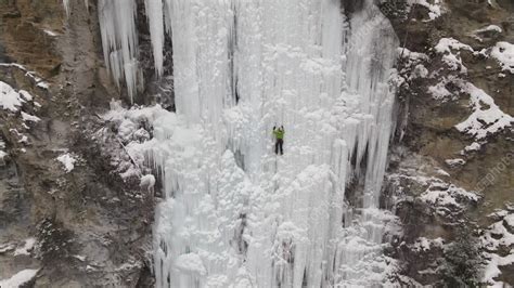 Ice Climber On Frozen Waterfall Aerial Stock Video Clip K0112371