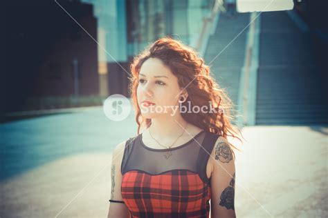 Young Beautiful Hipster Woman With Red Curly Hair In The City Royalty