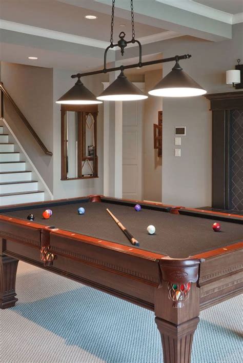 A Pool Table In The Middle Of A Room With Two Lights Hanging From Its