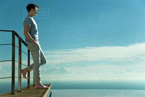Man Leaning Against Railing Looking At View Stock Photo Dissolve