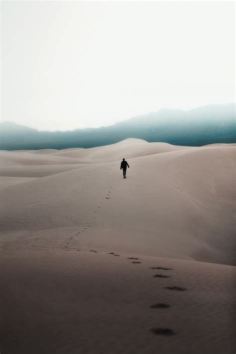 Man Walking Through The Desert Photo Free Image On Unsplash