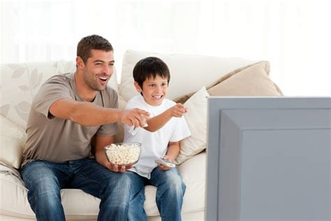 Familia Feliz Viendo Televisión Comiendo Palomitas De Maíz Foto Premium