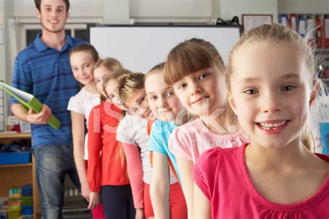 Teacher With Line Up Of Children In Class Stock Photos