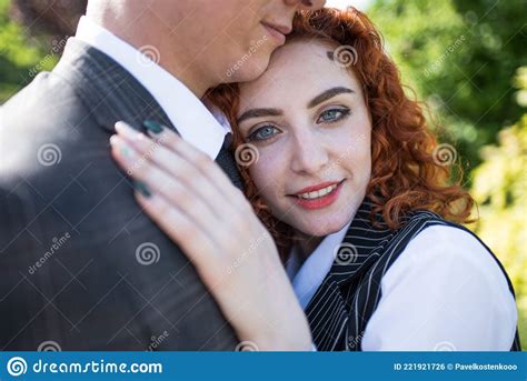 Happy Redhead Husband And Wife Standing And Hugging In Nature Stock