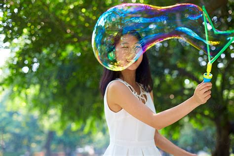 Happy Young Asian Woman Playing Bubble Outdoor By Bo Bo Young Woman
