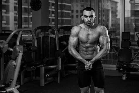 premium photo portrait of a physically fit man showing his well trained body in gym