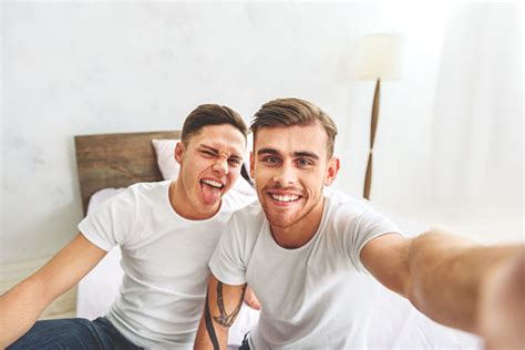 Cheerful Homosexual Couple Making Selfie In Bedroom 2人のストックフォトや画像を多数ご用意 Istock