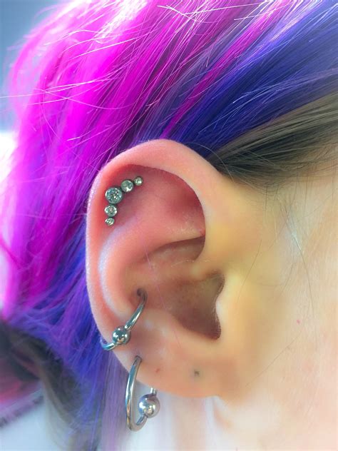 A Woman With Purple Hair And Piercings On Her Ear