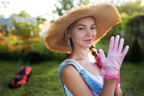 premium photo women gardener close up a sexy girl in a hat mows the grass near the house with
