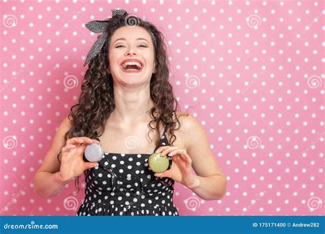 Pretty Girl With Kinky Hair Tied With Pin Up Bow Is Playing Around Keeping Two Macaroons On Her