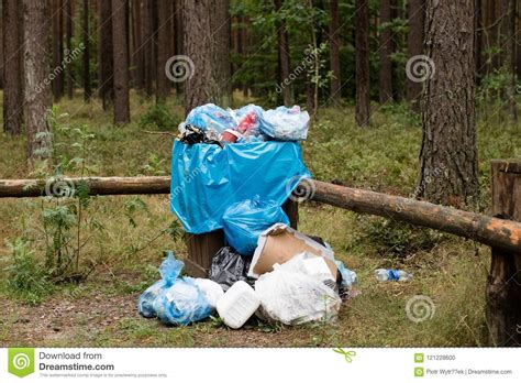 Garbage In A Full Basket In A Forest Parking Lot Cluttered Environment