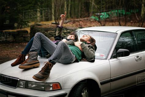 Young Couple Laying On Hood Of Car Stock Photo Dissolve