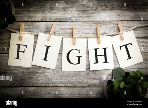 A Set Of Printed Cards Spelling The Word Fight On An Aged Wooden