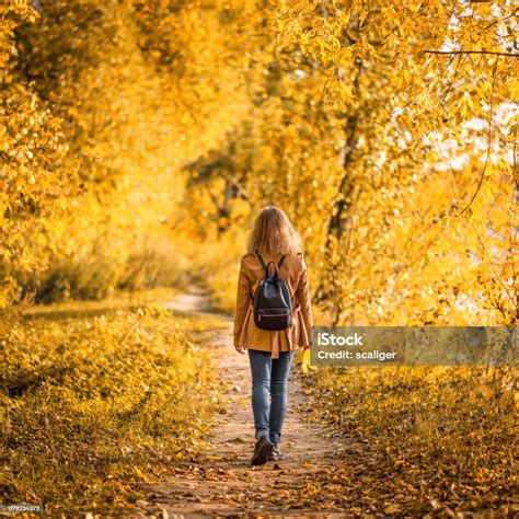 Adult Girl Walking Away Alone On Path In Autumn Forest Lonely Young