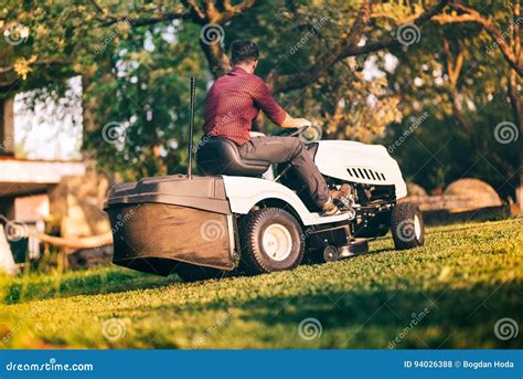 Professional Gardner Worker Using Lawn Mower For Cutting Grass In
