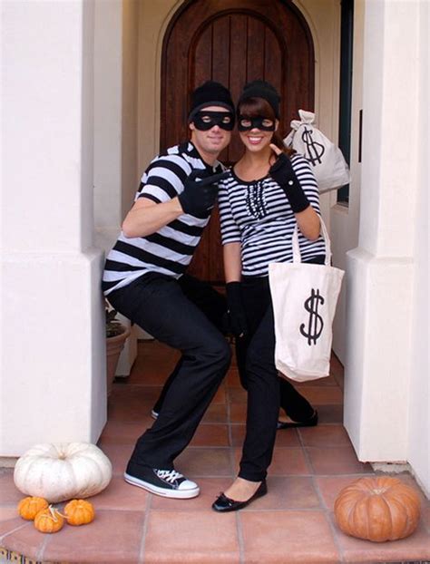 Two People Dressed Up In Costumes Posing For A Photo With Pumpkins On The Ground