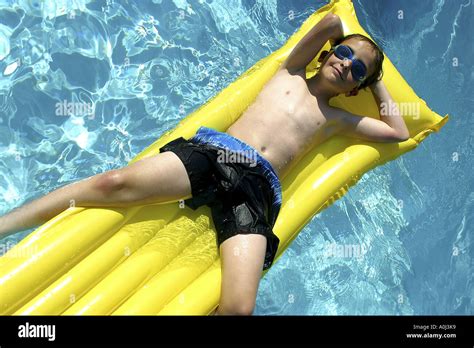 Portrait Of A Boy Floating On A Raft In A Swimming Pool Stock Photo Alamy