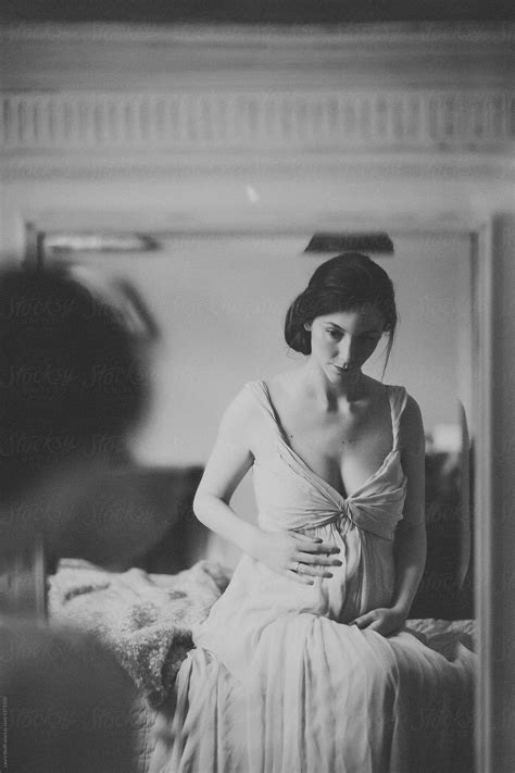 Black And White Portrait Of Pregnant Woman Caressing Her Belly While