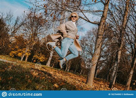 Beautiful Woman In Autumn Park Jumping And Smiling Stock Photo Image