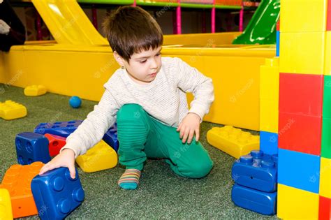 Un Niño En Edad Preescolar Juega Con Grandes Bloques De Construcción En