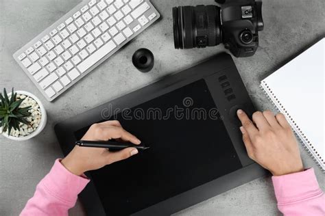 Female Designer Working With Graphic Tablet At Grey Stone Table Stock