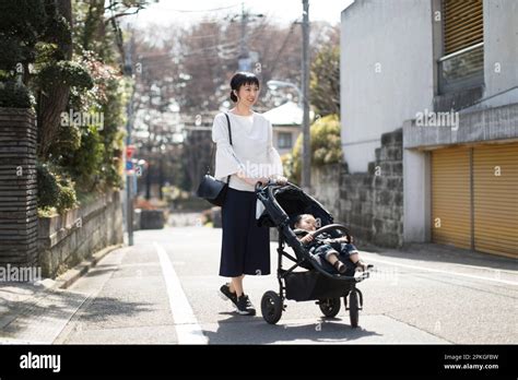 Mother Walking With Baby In Stroller Stock Photo Alamy