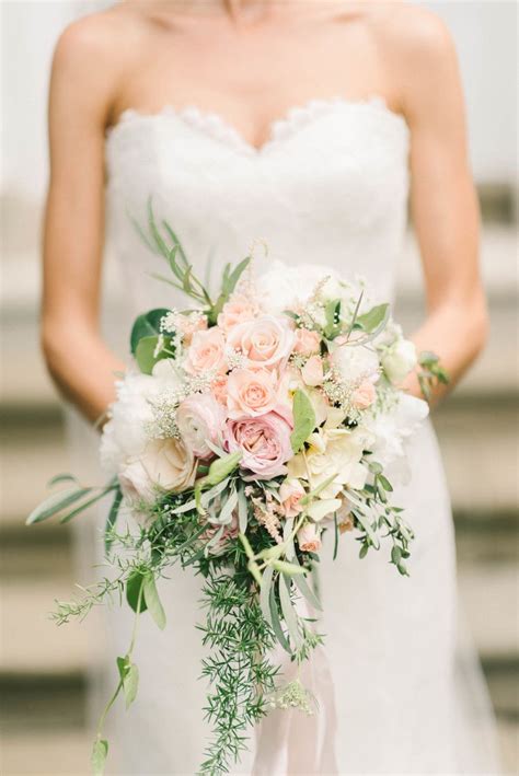 A Bridal Holding A Bouquet Of Pink And White Flowers