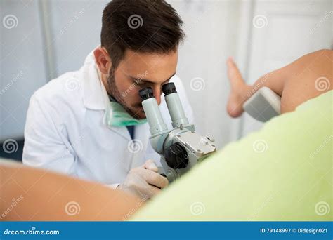 professional gynecologist examining her female patient on a gynecological chair royalty free