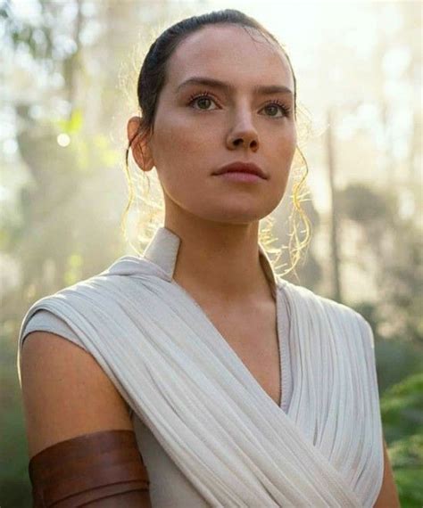 A Woman In A White Dress Standing In Front Of Trees With Her Arm