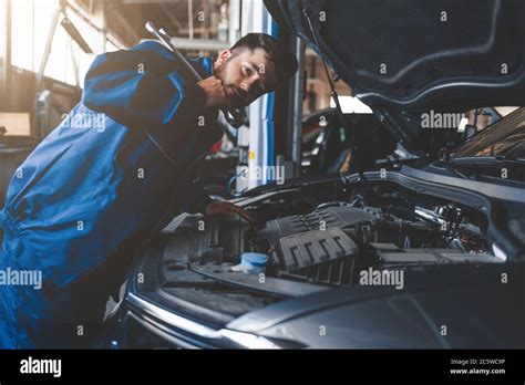 Auto Mechanic With Wrench Over Car Hood Car Repairman In The Service