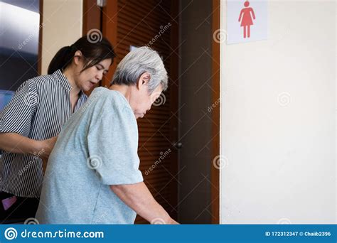 Female Caregiver Is Helping Support Elderly Woman Walk Into The Restroom Carefullyasian Senior