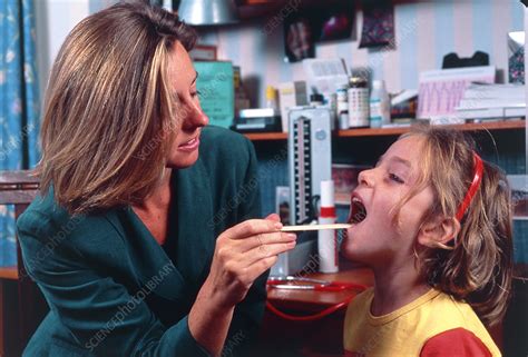 Doctor Checking Girls Throat For Tonsillitis Stock Image M8250376
