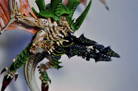 A Close Up Of A Dragon Figurine On A White Surface With Green And