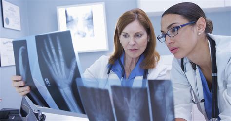 Two Medical Colleagues Looking At X Rays Indoors Medical Office Florida Orthopaedic Associates