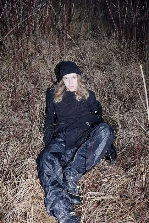 Blonde Man With Long Hair Wearing All Black Clothes In Nature By