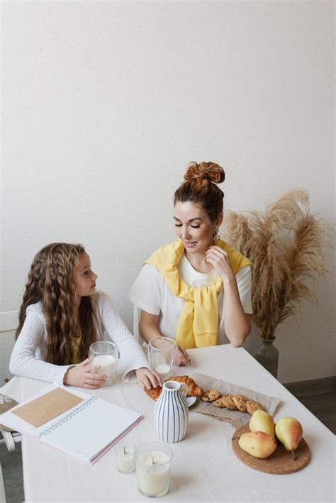 Mom And Daughter In The Kitchen Have Breakfast With Milk And Delicious Cookies Stock Image