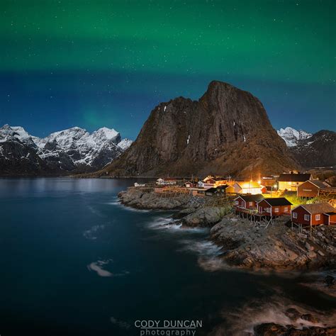 Northern Lights Aurora Borealis Shine In Sky Over Hamnøy Near Reine